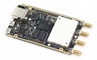 Black AntSDR E310 PCB with Zynq SoC and four SMA connectors.