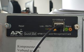 Changing the IP of an APC AP9617 network management card requires a serial console wired through the Smart-UPS itself, with APC's non-standard DE-9 cable at 2400 8N1.